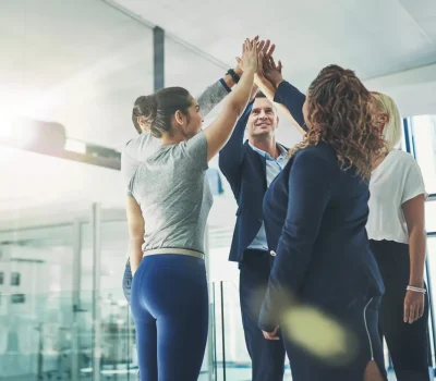 Shot of a diverse group of coworkers high fiving together in an office